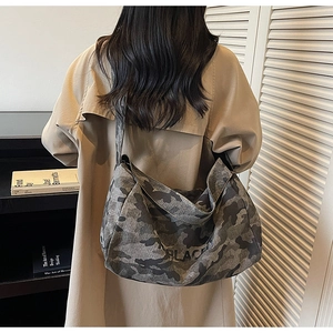 Détail du sac messager camouflage gris avec texte PLACE et large bandoulière