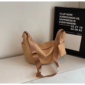 Dettaglio borsa a mezzaluna trapuntata marrone chiaro con pochette e tracolla larga