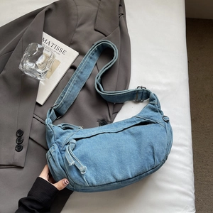 Détail du sac croissant en jean bleu clair avec large bandoulière réglable textile