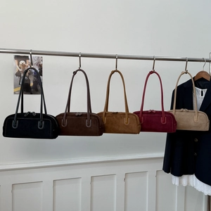 Detail showing five vintage suede baguette bags with contrast stitching and double zippers