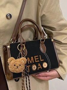 Sac à main vintage classique en toile noire et cuir marron avec breloque ours