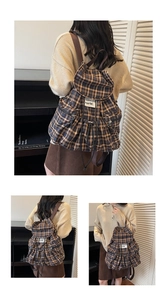 Detail of vintage plaid backpack with drawstring closure and buckle flap pocket