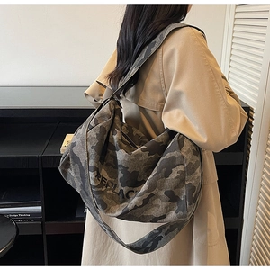 Détail du cabas en toile camouflage avec lettrage REPLACE noir et large bandoulière
