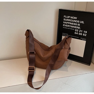 Dettaglio di una borsa hobo trapuntata marrone con trama a righe e tracolla larga