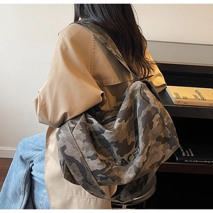 Détail du sac bandoulière en toile camouflage avec inscription décorative Replaced