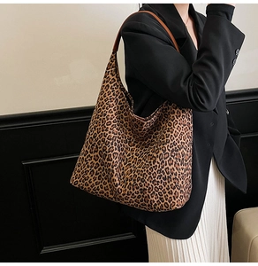 Chic leopard print tote bag with brown leather straps shown on model in minimalist setting