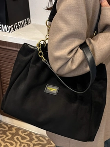 Large black minimalist tote bag with gold chain strap and leather wide shoulder strap