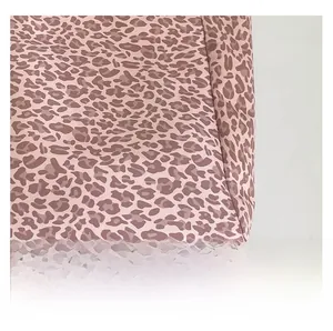 Détail du tissu à imprimé léopard rose avec couture à angle droit précise sur le sac cabas