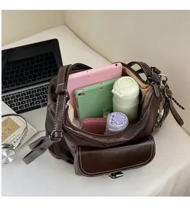 Detail view of a spacious brown leather tote bag interior holding a tablet and daily items