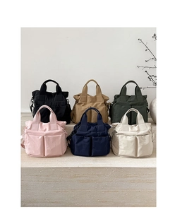 Collection of minimalist nylon crossbody bags in six colors shown on stone steps