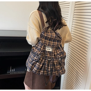 Detailed back view of a retro plaid backpack with drawstring closure and side zippers
