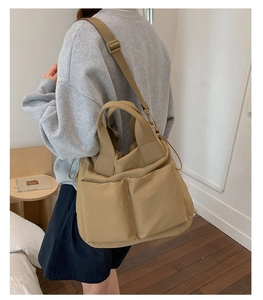 Detailed side view of khaki large nylon tote bag featuring adjustable shoulder strap and pockets