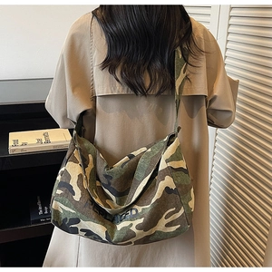 Détail d'un grand sac bandoulière en toile camouflage avec logo REPLACED imprimé noir