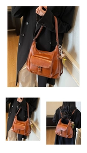 Detail of retro brown leather bag with white contrast stitching and plush charm