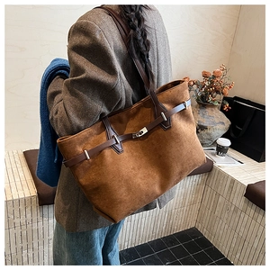 Détail du grand sac cabas en daim caramel avec lanière en cuir et fermoir argenté