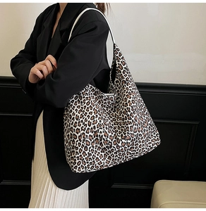 Chic leopard print tote bag styled as an underarm shoulder bag on a model