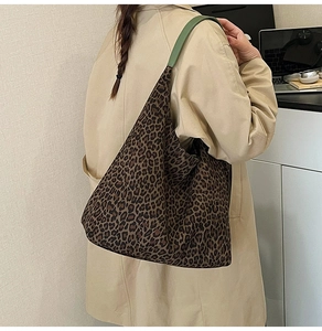 Detailed side view of large leopard print tote bag with contrasting green shoulder straps