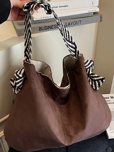 Brown suede tote bag with woven herringbone handles and large decorative knot details