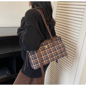 Detail of vintage plaid tote bag featuring brown leather straps and cute bear embroidery