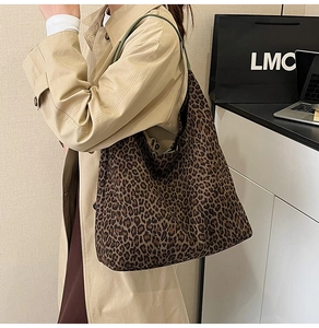 Leopard print tote bag with green leather straps styled with a beige trench coat