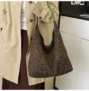 Detail of a leopard print hobo tote bag featuring olive green handles for women