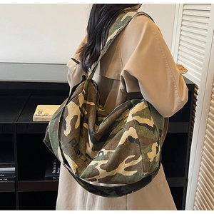 Détail du sac hobo en toile camouflage robuste avec une large bandoulière