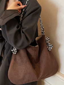 Dark brown suede tote bag featuring contrasting black and white striped shoulder strap