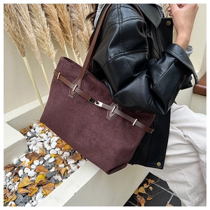 Détail d'un grand sac cabas en daim marron avec sangle en cuir et boucle en métal chic