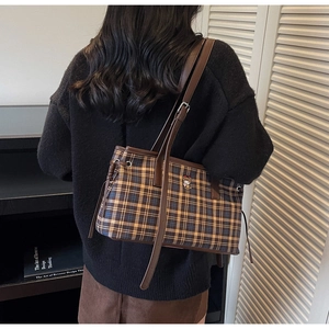 Detail of British plaid tote bag featuring a cute bear embroidery and brown leather strap