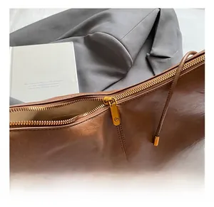 Detail of premium gold-toned zipper and fine stitching on brown vintage leather bag