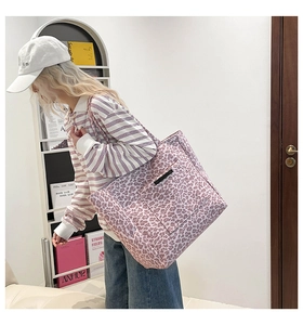 Détail du sac cabas en toile à imprimé léopard violet avec poche avant et logo cousu