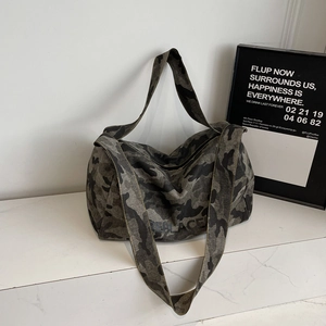 Détail du cabas en toile camouflage avec lettrage REPLACE noir et coutures jaunes