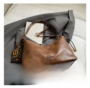 Detailed macro view of dark brown retro leather texture and brand tag on a tote bag
