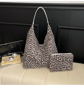 Detail view of leopard print tote bag set with matching small zipper pouch and white handles