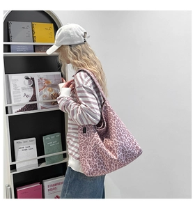 Détail du sac cabas en toile à imprimé léopard rose avec grande capacité et étiquette tissée