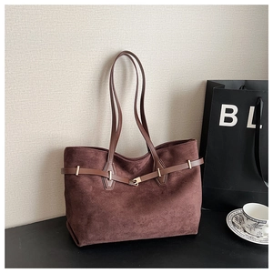Détail d'un grand sac cabas en daim marron avec ceinture en cuir et boucle dorée