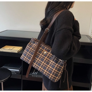 Detail of the checkered tote bag with a cute bear embroidery and brown leather strap