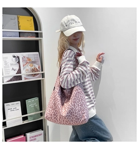 Détail du sac cabas en toile à motif léopard rose montrant la texture douce et la forme hobo