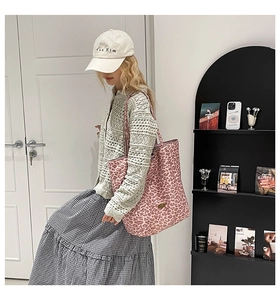 Vue détaillée du grand sac cabas en toile à imprimé léopard rose porté avec style décontracté