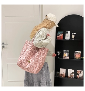 Détail du sac fourre-tout en toile léopard rose avec logo métallique et grande capacité