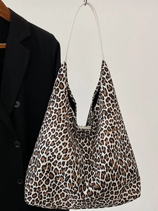 Chic leopard print tote bag with white shoulder strap shown next to a black blazer