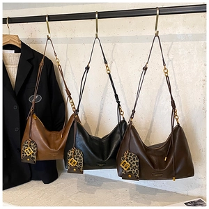 Three crescent tote bags in brown, black, and coffee colors with leopard print charms