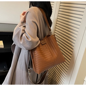 Détail du sac cabas marron tressé avec bandoulière large en toile et sangle en cuir