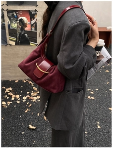 Vue détaillée d'un sac sous le bras en daim bordeaux avec boucle métallique en demi-lune dorée