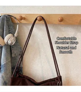 Details der bequemen schmalen Schultergurte einer dunkelbraunen Wildleder-Tasche