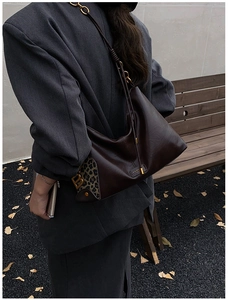 Detailed shot of dark brown shoulder bag with leopard print accent and gold B pendant