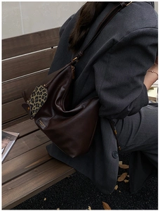 Detailed view of dark chocolate leather hobo bag with leopard print pony hair texture