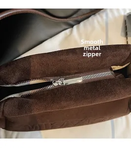 Detailaufnahme des hochwertigen Silber-Reißverschlusses an brauner Wildledertasche