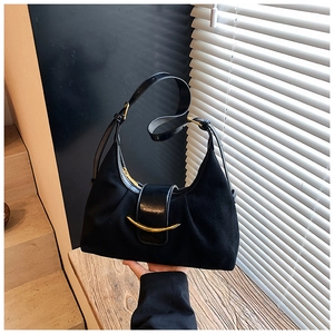 Détail du sac demi-lune noir avec texture en daim mat et fermoir métallique doré