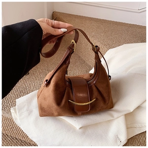 Détail du sac à bandoulière en daim marron foncé avec boucle métallique et sangle en cuir
